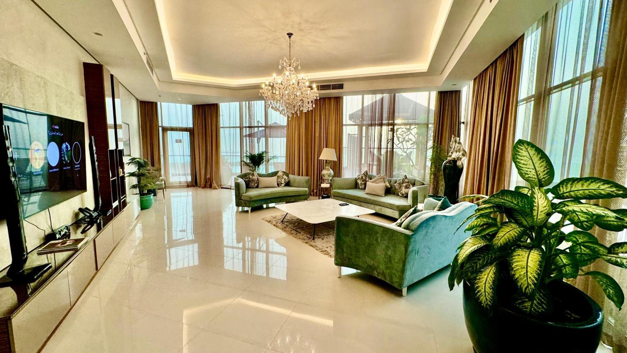 Lagoona Beach Luxury Resort And Spa Manama Exterior foto The photo depicts a spacious and elegantly designed living room. The room features large windows allowing natural light to flood in, accompanied by sumptuous curtains. The furniture includes a pair of soft green sofas and a centerpiece coffee table s