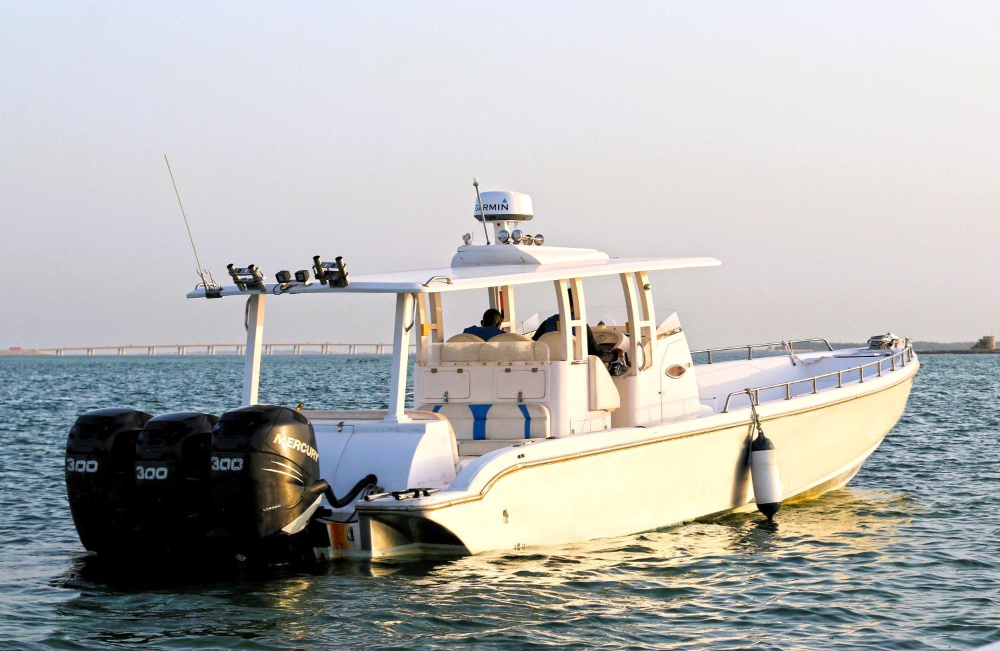 Lagoona Beach Luxury Resort And Spa Manama Exterior foto The photo shows a large, white motorboat equipped with three powerful outboard engines at the stern. The boat has a sleek design, with a spacious open deck and a covered cabin area that likely provides shelter and controls for navigation. The scene i